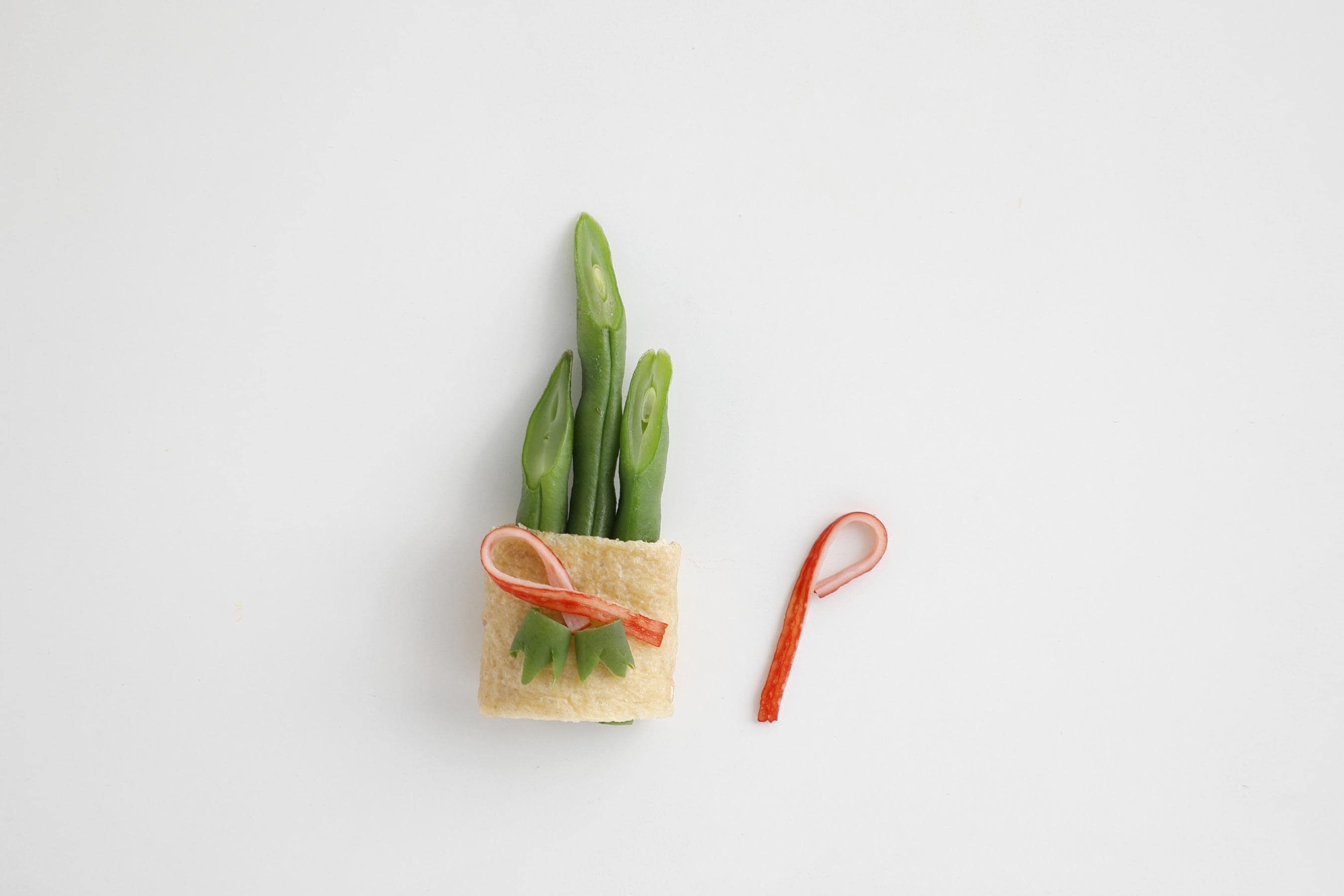 Wrap the green beans in the aburaage, then decorate with small strips of kanikama and green beans.
