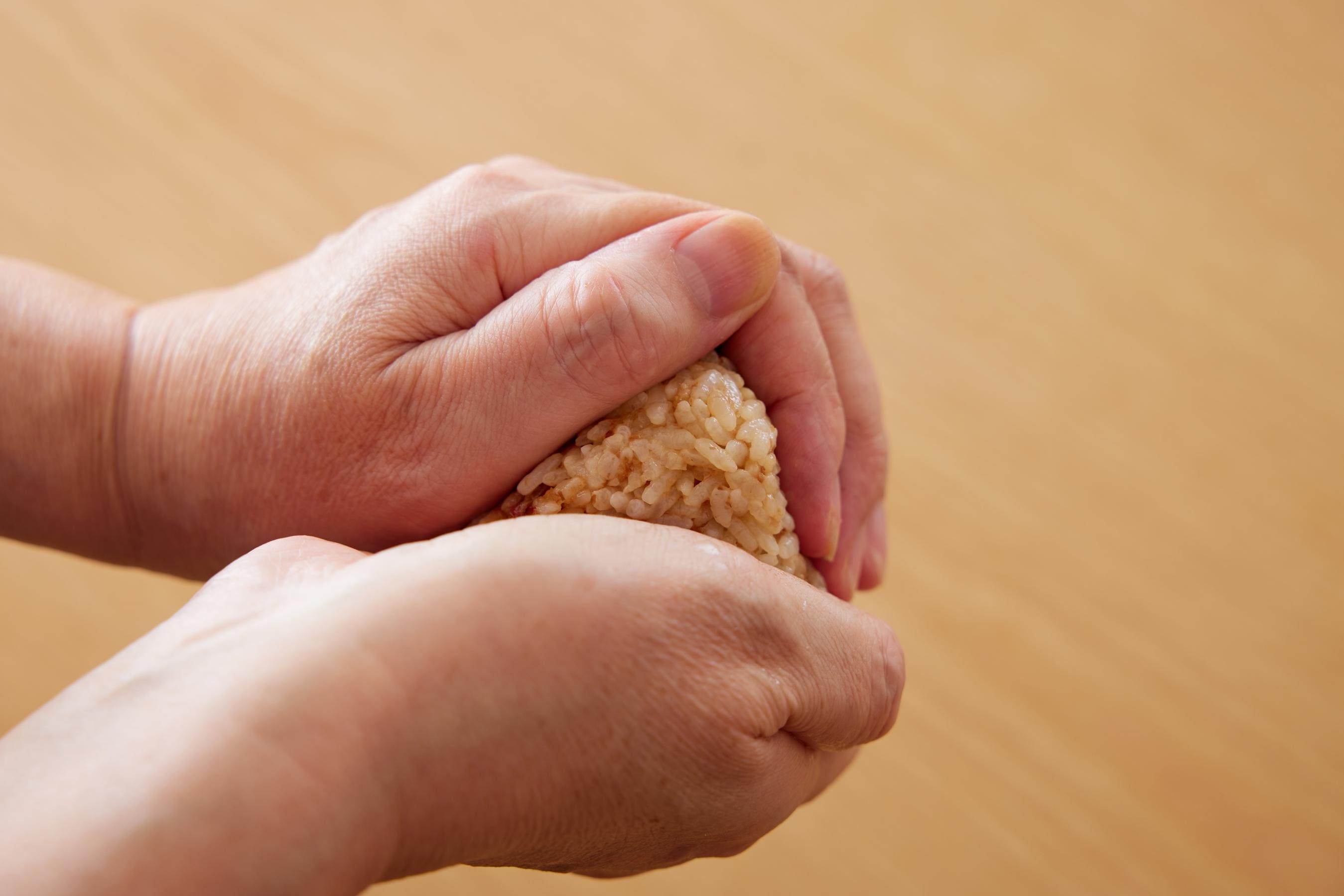 gently squeezing the rice ball with hands