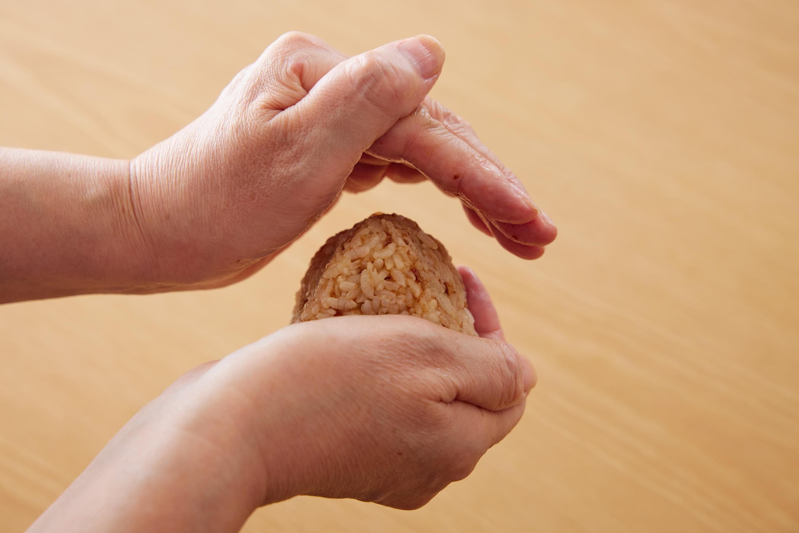 gently squeezing the rice ball with hands
