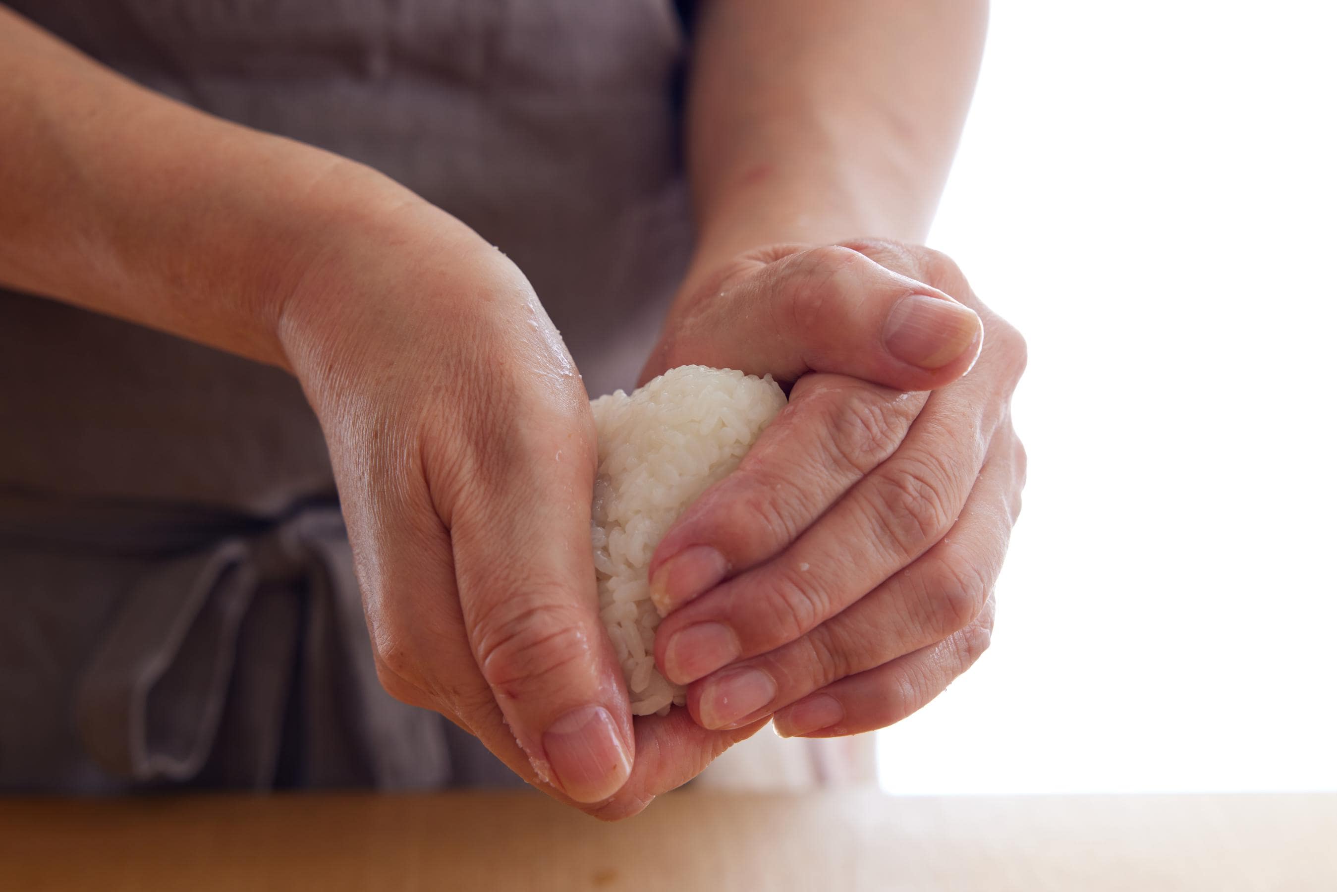 gently squeezing Onigiri with hands