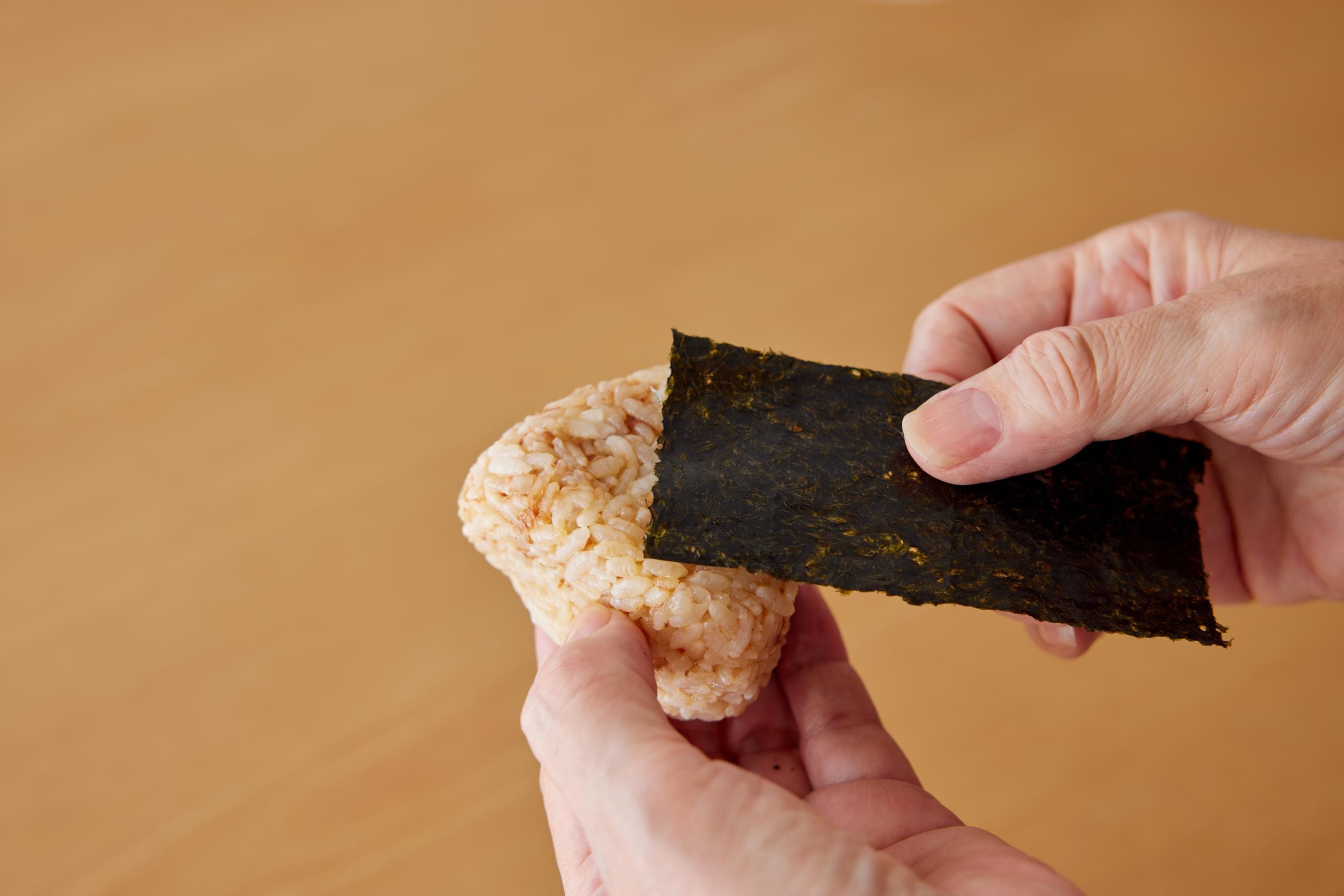 wrapping onigiri with a strip of seaweed