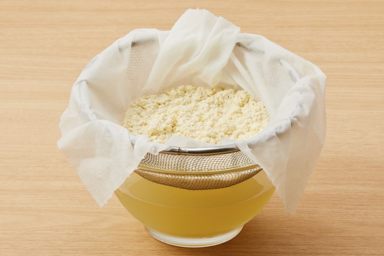 Strain the cheese mass in a colander lined with paper towels, let it drain for about an hour, wrap the towel, and gently squeeze out the remaining water.