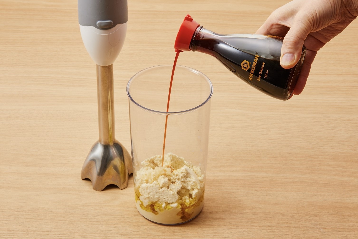 Put the cheese in a container and add olive oil, soymilk, garlic, and soy sauce. Blend it with a hand blender.