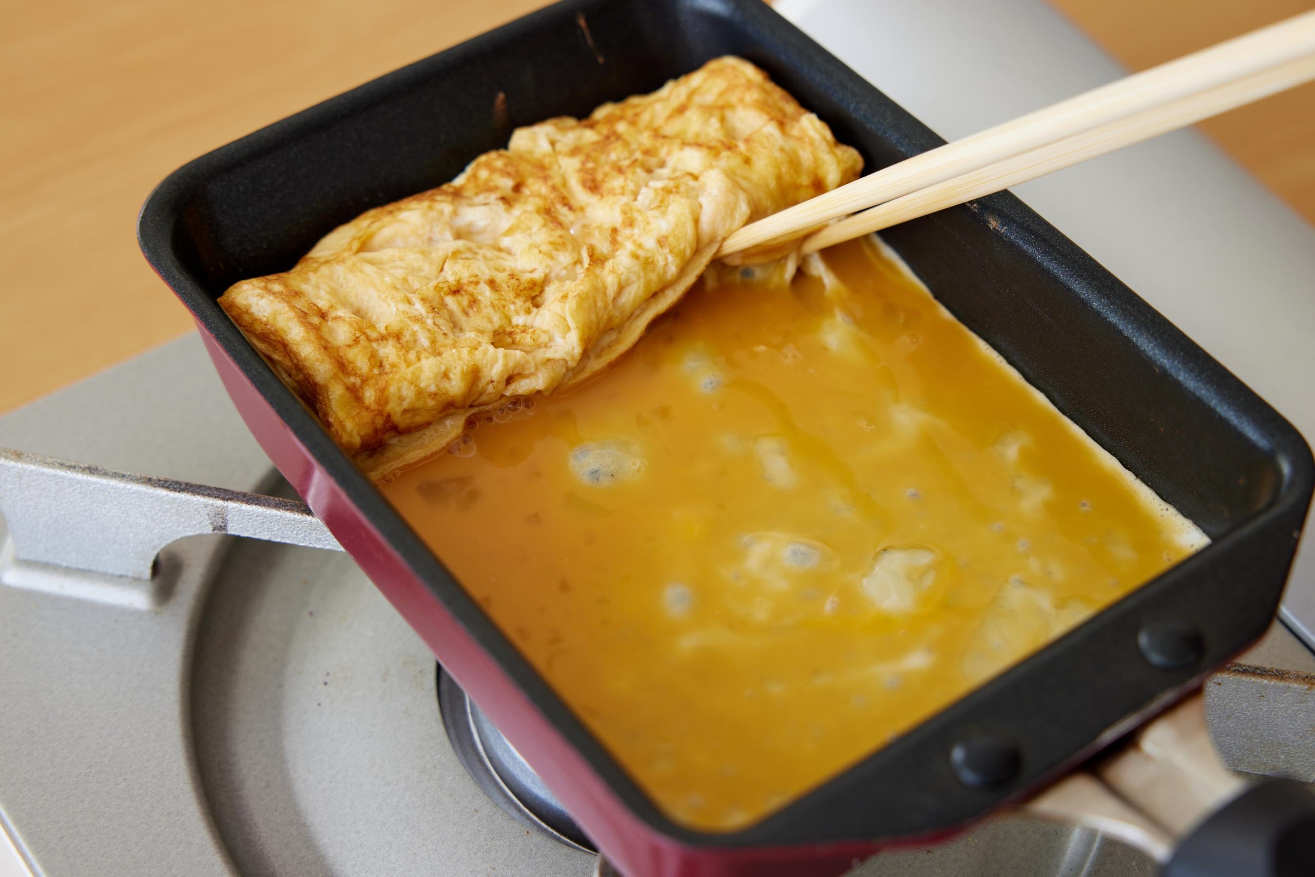 Lift up the near end of the fried egg to allow the egg mixture to run underneath it.