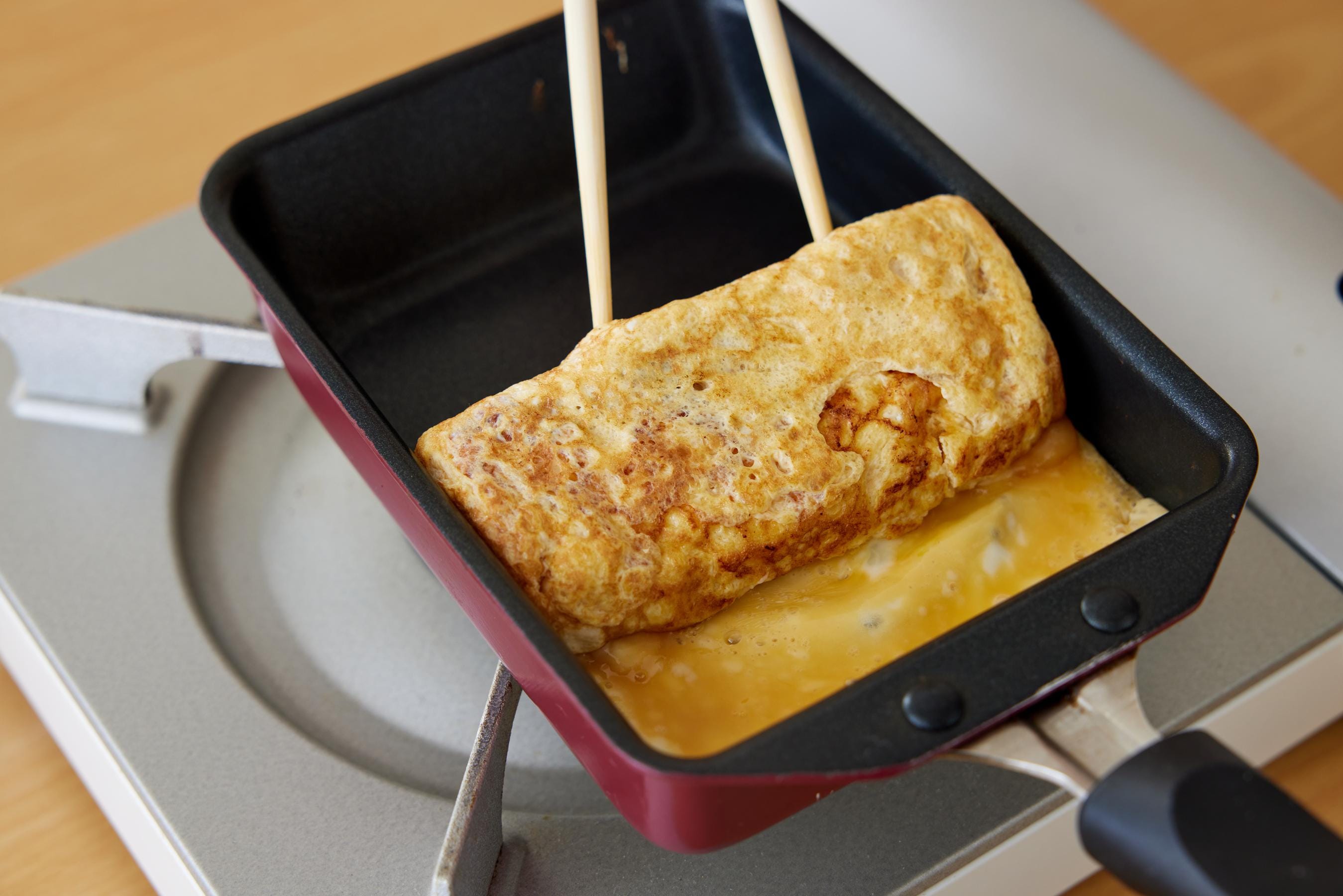 Roll Tamagoyaki from the far end back to the near end.