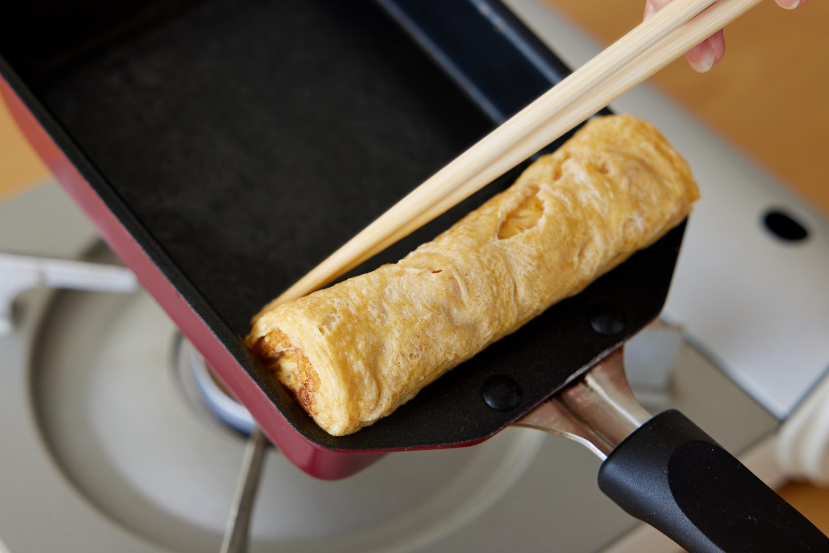 Press the Tamagoyaki against the near edge of the Tamagoyaki pan.