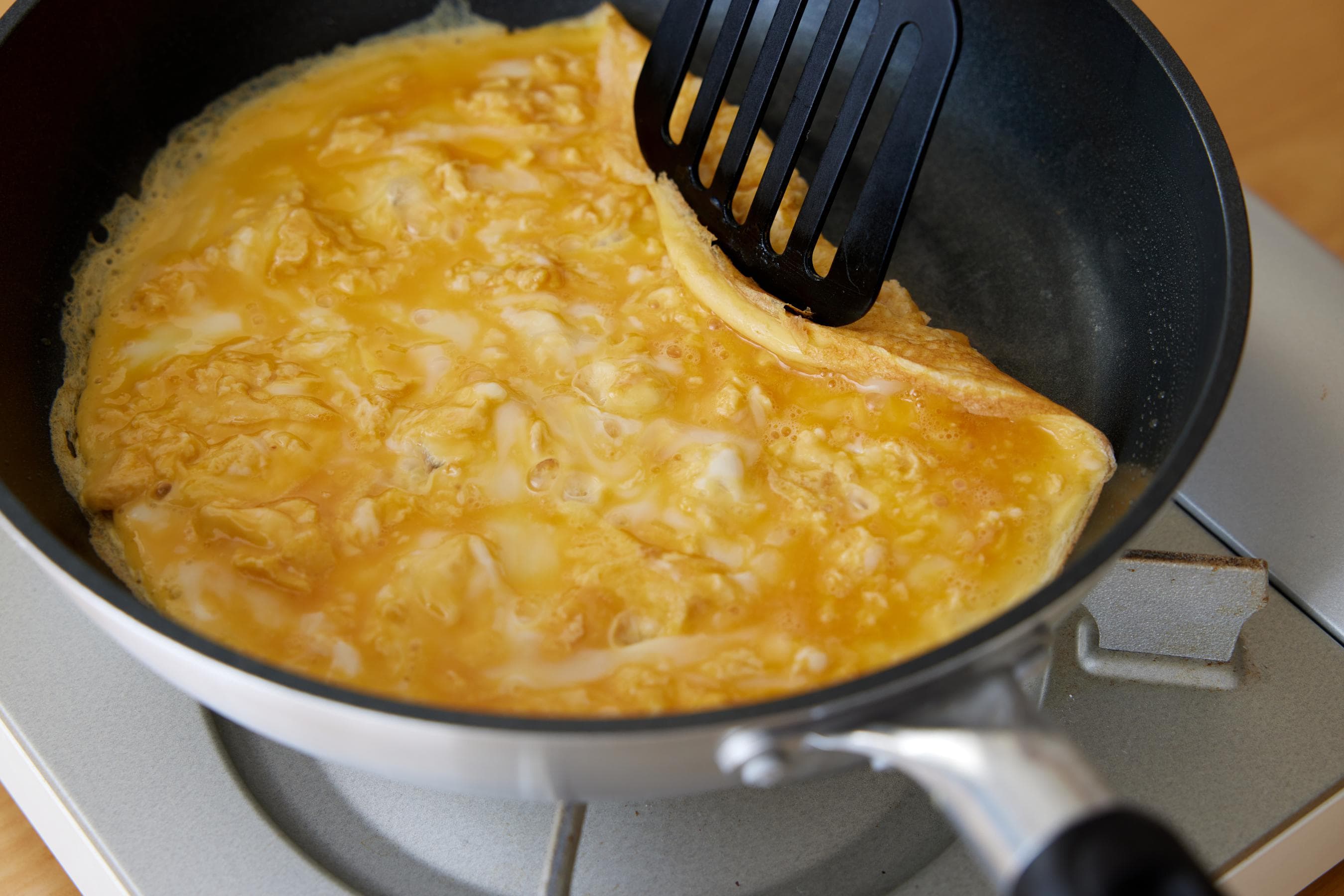 Lift up and fold the fried egg from one of the side edges.
