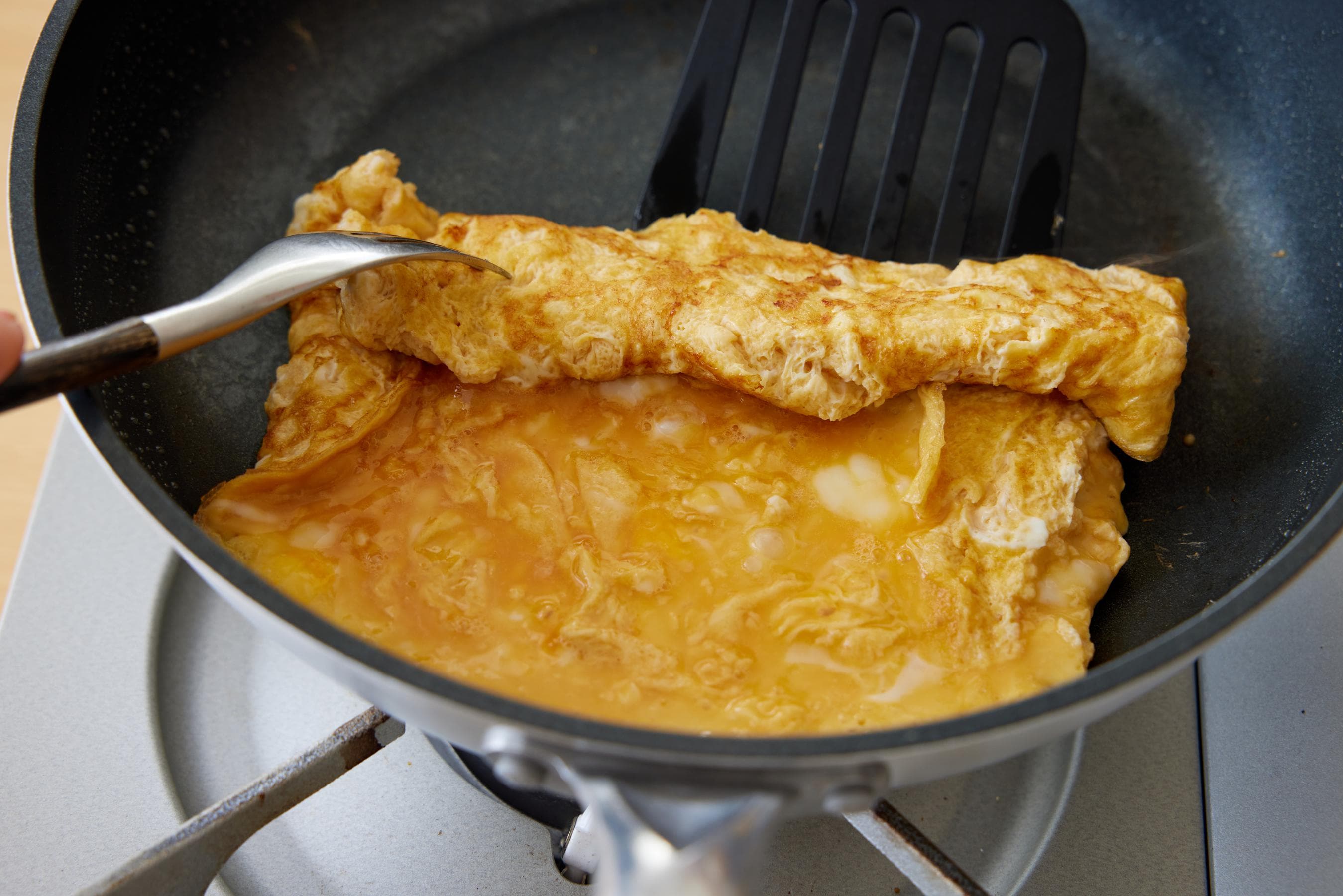 Roll up the fried egg from the far side.