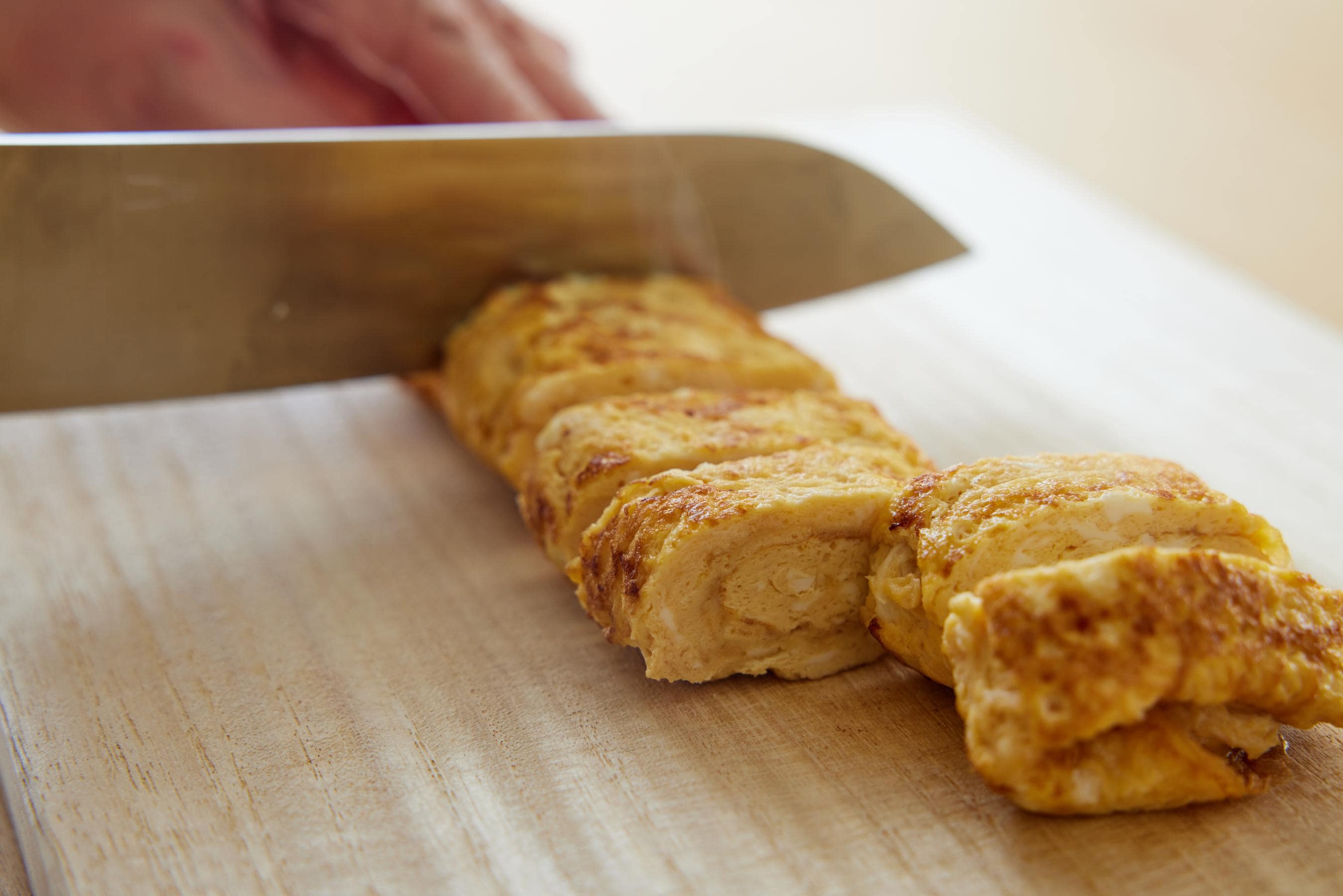 Tamagoyaki being cut into bite-sized pieces.