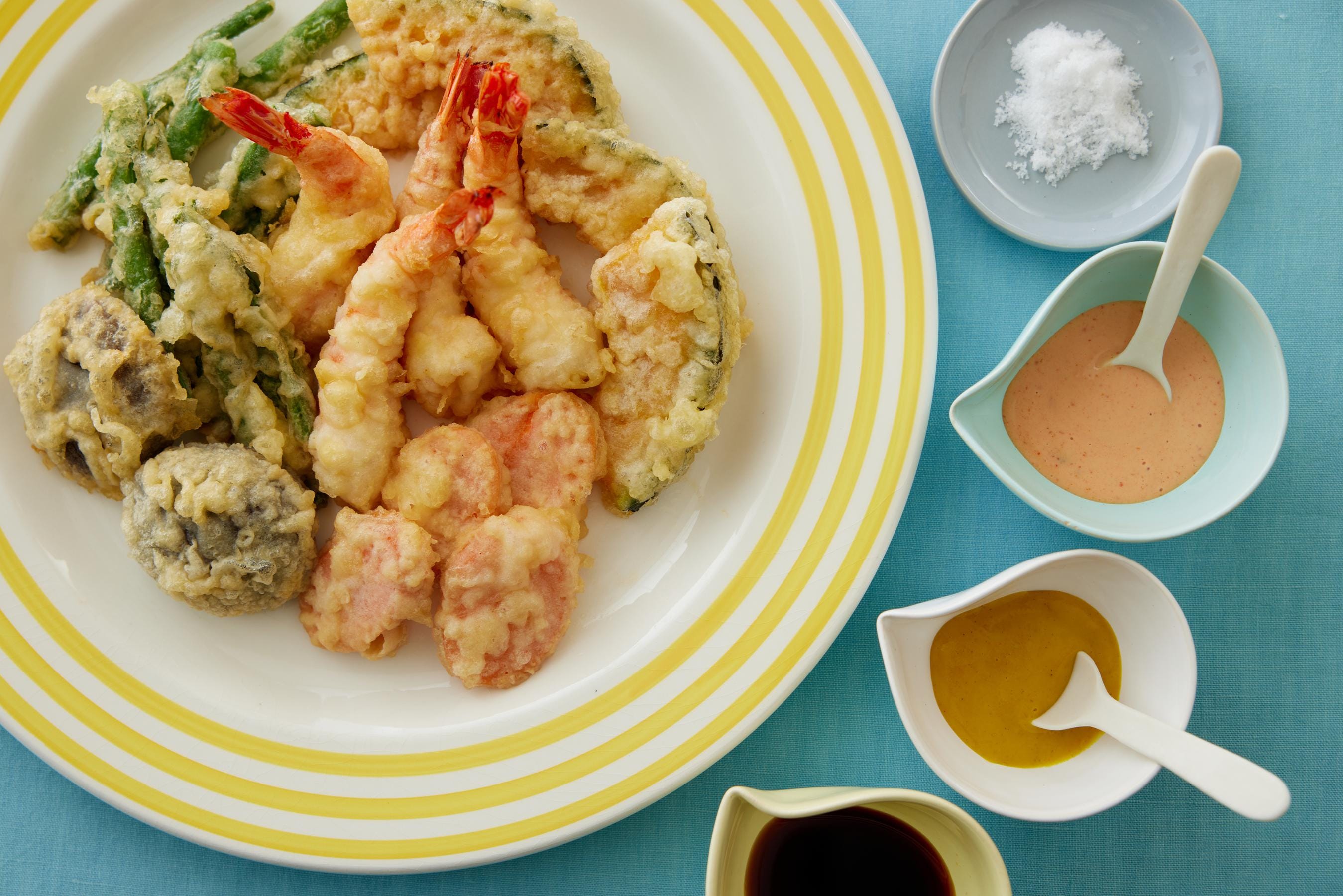 Assorted Tempura with different sauces on a plate.