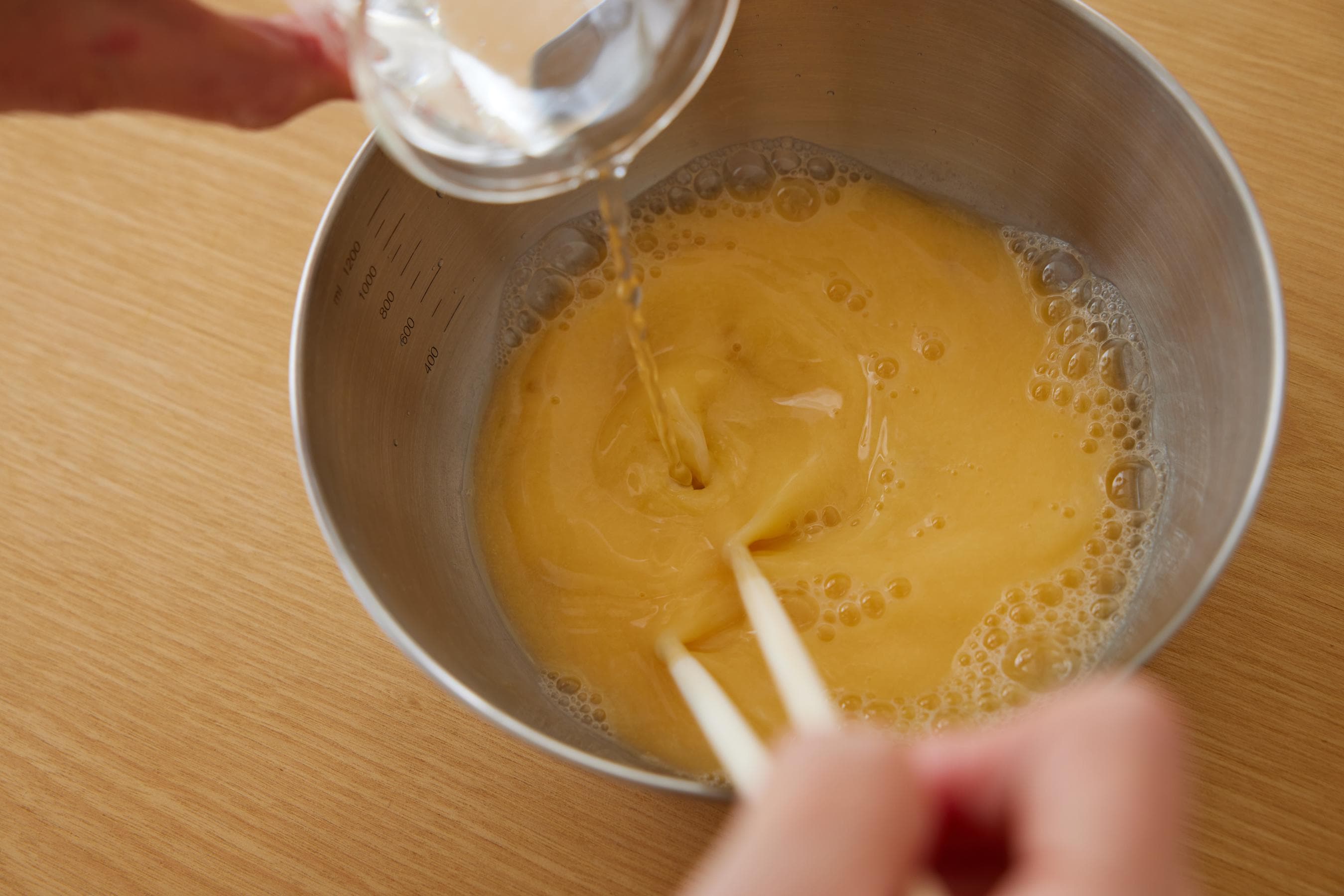 Beating egg in a bowl.